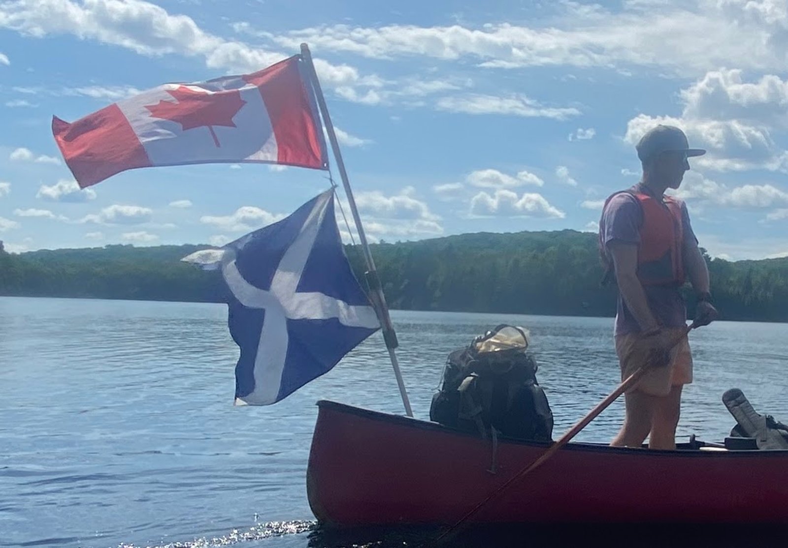 Paddling a canoe flying the Canadian and Scottish flags