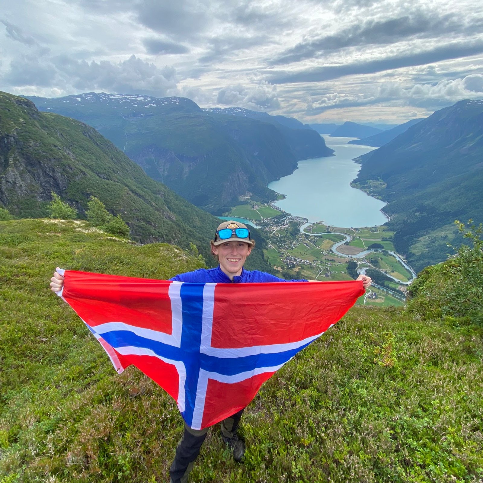 Holding the Norwegian flag above a fjord